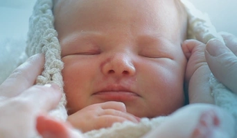 Bebé recién nacido durmiendo plácidamente, fruto de un tratamiento de reproducción asistida en FIV Valencia.