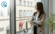 Mujer pensativa mirando por la ventana.