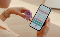 Mujer consultando app de seguimiento de ciclos menstruales.